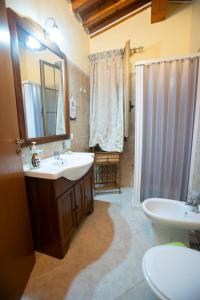 een badkamer met een wastafel, een toilet en een spiegel bij Le Villette Luisa in Lampedusa