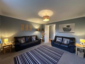 a living room with two couches and a rug at Brada View Bamburgh in Bamburgh