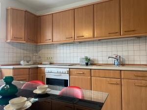 eine Küche mit Holzschränken und einem Tisch mit Geschirr in der Unterkunft FeWo- PPF in Sonneberg