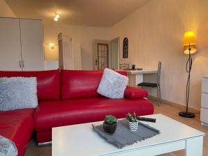 ein rotes Sofa in einem Wohnzimmer mit einem Tisch in der Unterkunft FeWo- PPF in Sonneberg