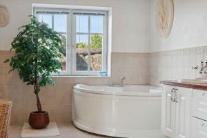 a bathroom with a tub and a potted plant at Large Holiday Home By The Limfjord in Thyholm +31 photos