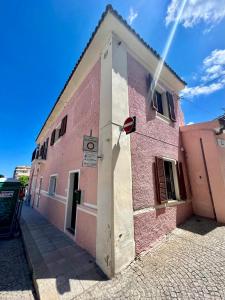a pink building with a white door on a street at Luxury studio Garibaldi - perfect for couples - fully Equipped - Historical Centre in Olbia