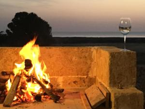 a fire pit with a glass of wine at Nido del Salento in Villaggio Resta
