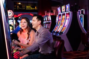 a man and a woman sitting at a slot machine at Choctaw Casino Hotel – Pocola in Pocola