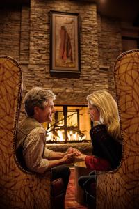 un hombre y una mujer sentados en sillas estrechando las manos en Choctaw Casino Hotel – Pocola, en Pocola