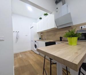 a kitchen with white cabinets and a wooden table at Anna Home in Telde