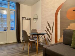 a living room with a table and chairs and a couch at Résidence Vendôme in Vichy