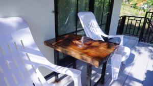 a wooden table and two white chairs on a porch at TinyHouse at TigerCave in Ko Bu Bu