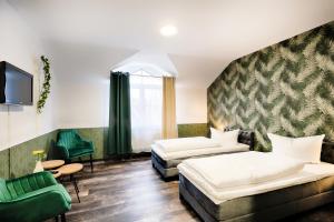 a hotel room with two beds and a couch at Hotel Apfelblüte in Wendorf