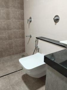 a bathroom with a toilet and a sink and a shower at Luxury Stay with Outdoor Pool and Gym near Bangalore Airport in Bengaluru