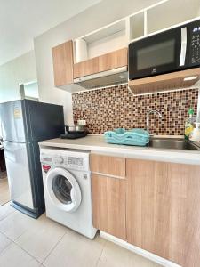 una cocina con lavadora y microondas en Cozy 1 bedroom in prime Bangtao, en Bang Tao Beach