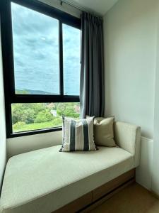 Sofá en habitación con ventana grande en Cozy 1 bedroom in prime Bangtao, en Bang Tao Beach 13 fotos más