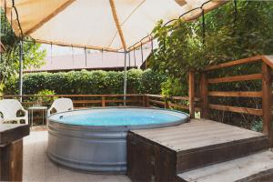 a hot tub in a garden with a tent at ווילו בערבה in ‘En Yahav