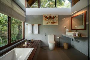 a bathroom with a tub and a toilet and a sink at Treehouse Chalets - A Curated Experience of Unique Waterfall Treks and Scenic Hikes in Belihuloya +60 photos