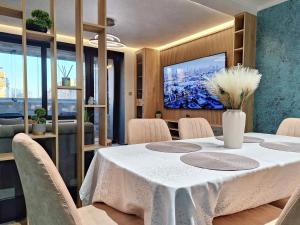 a dining room with a table and a tv at Апартамент Девио Чар in Ruse