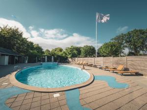 a large swimming pool with chairs and a flag at Park Lodge in Millinge