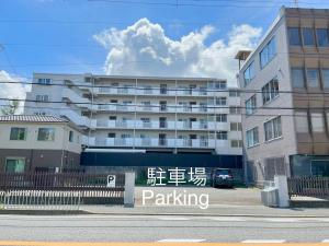 淡輪にあるMuji House Osaka Sannan Hotel 大阪泉南酒店良築 の駐車場の標識が正面にある建物