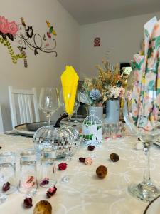a table with wine glasses and flowers on it at Colț Viu Deluxe in Şimon