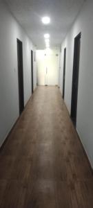 un corridoio vuoto con pareti bianche e pavimenti in legno di Hotel The Lotus a Jaipur
