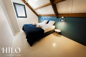 een slaapkamer met een bed met een blauwe muur bij Kaz'Pépite Villa Saint Gilles by HILO Collection in Saint-Paul +14 foto's