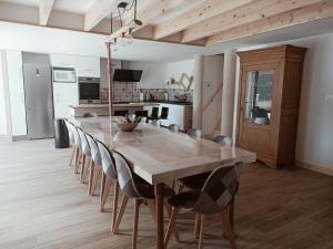 a dining room with a large wooden table and chairs at Le Hangar de Papi in La Charrière