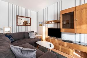 a living room with a couch and a tv at Deichperle Friedrichskoog Spitze in Friedrichskoog