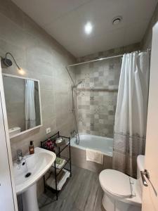 Un baño con bañera, lavabo e inodoro. en Calma, en Tarifa
