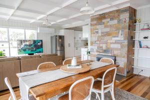 a kitchen and dining room with a wooden table and chairs at Metung Holiday House in Metung
