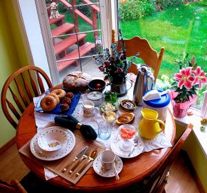 uma mesa de madeira com comida e bebidas em The Grateful Bed B'n'B em Prince George