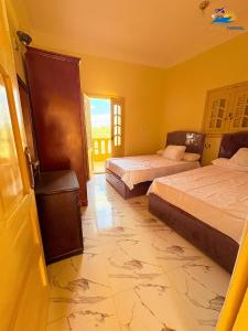 a bedroom with two beds and a window at فندق العجواني in Siwa