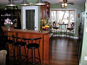 a kitchen with a bar with stools and a dining room at The Grateful Bed B'n'B in Prince George