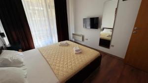 a hotel room with two beds and a mirror at ASPEN GOLF RESORT Ski & Spa RELAX APARTMENT in Bansko +47 photos