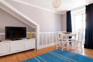 リスボンにあるLisbon Sant'Ana Restelo 1br terraceのテレビとテーブルと椅子のあるリビングルーム