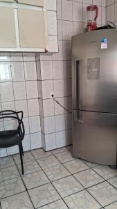 uma cozinha com um frigorífico de aço inoxidável e uma cadeira em SP Hostel em São Paulo