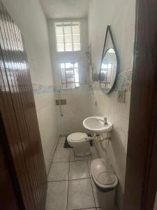 um banheiro com uma pia, um vaso sanitário e um espelho em SP Hostel em São Paulo