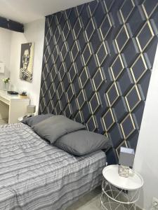 a bedroom with a bed with a black and gold headboard at Le Studio de Lucie in Villeurbanne