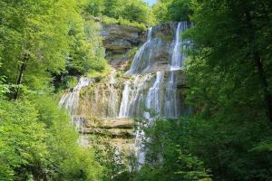 a waterfall in the middle of a forest at Sympa Studio totalement équipé in Saint-Germain-de-Joux