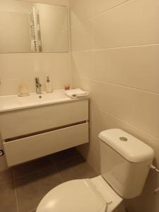 a white bathroom with a toilet and a sink at Sympa Studio totalement équipé in Saint-Germain-de-Joux
