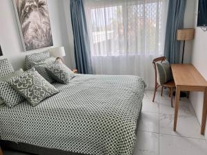 een slaapkamer met een bed, een bureau en een raam bij Beautiful Broadbeach Living! in Gold Coast +41 foto's