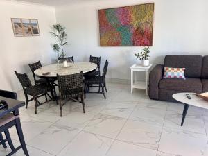 een woonkamer met een bank, een tafel en stoelen bij Beautiful Broadbeach Living! in Gold Coast