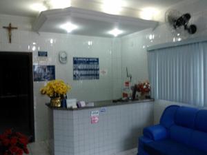 Santo AnastácioにあるFlorença Hotelの青いソファとカウンターのある待合室