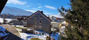 a house in the snow with a mountain in the background at Ferienwohnung Meusburger in Hittisau