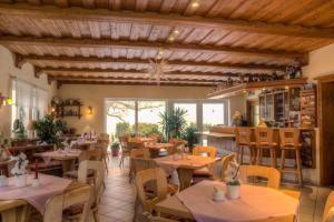 a restaurant with wooden ceilings and tables and chairs at Auf der Heide Gasthof & Pension in Waltersdorf
