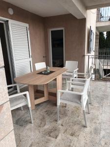 a wooden table and chairs on a patio at Apartmani Dajana in Primošten