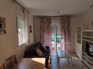 ein Wohnzimmer mit Sofa und Tisch in der Unterkunft Vera Playa Apto 1-4 Personas Piscina Parking WI-FI in Playas de Vera