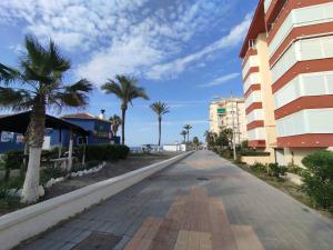 eine leere Straße mit Palmen und einem Gebäude in der Unterkunft Torrox Costa Loft Playa Wi-Fi Paseo Marítimo in Torrox