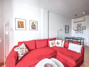 un sofá rojo en una pequeña sala de estar en Apartment with pool near Burriana beach, Nerja, en Nerja