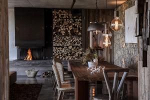 a dining room with a table and a fireplace at Areias do Seixo Villas in Santa Cruz