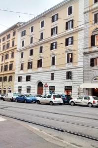 un gran edificio con coches estacionados frente a él en Hotel Farini, en Roma