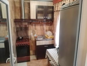 a small kitchen with a stove and a refrigerator at Casa de vacanta in Eforie Nord